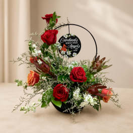 Red roses and white flowers in a black basket with a cardinal memorial sign