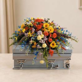 Colorful floral spray on a silver casket