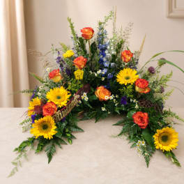 Colorful floral spray with sunflowers and orange roses on a table