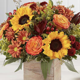 Autumn bouquet of sunflowers, roses, and mums in a wooden box
