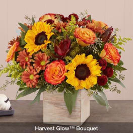 Bouquet of sunflowers, roses, and mums in a wooden cube vase