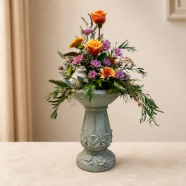 Colorful flower arrangement in a decorative pedestal vase
