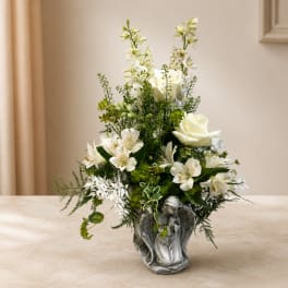 White floral arrangement in a silver angel vase