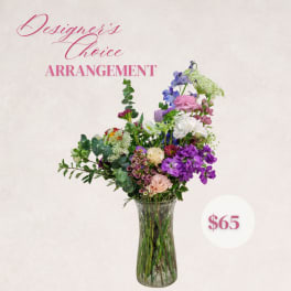 Mixed flower arrangement in a clear glass vase with pink and purple blooms
