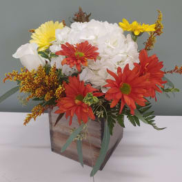 Mixed bouquet in a wooden box with white, red, and yellow flowers