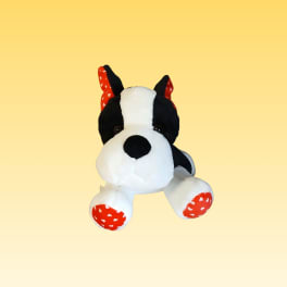 Black-and-white plush dog with red polka-dot ears and paws