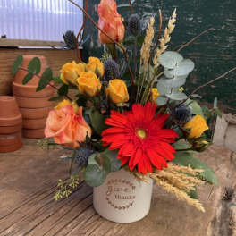 Mixed bouquet in a white bucket with red and peach flowers