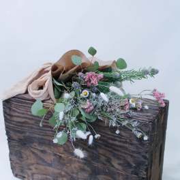 Wildflower bouquet in brown paper on a rustic wooden box