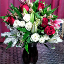 Bouquet of red and white roses with lilies in a black vase