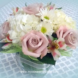 Pink roses and white daisies arranged in a clear vase