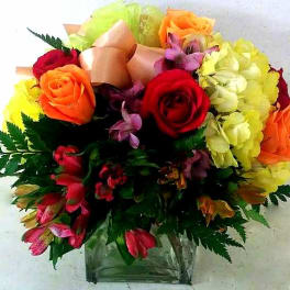 Mixed bouquet of roses and lilies in a clear glass vase