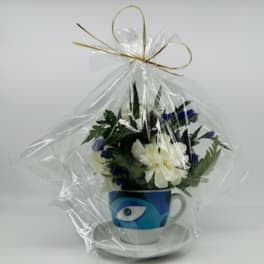 Wrapped flower arrangement in a blue mug with an eye design