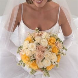 Bride holding a bouquet of cream, blush, and yellow roses