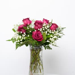 Pink roses and baby's breath in a clear glass vase