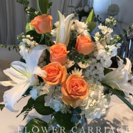 Orange roses and white lilies in a glass vase