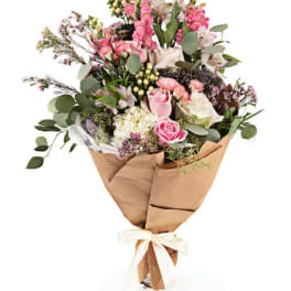 Pink and white mixed bouquet wrapped in brown paper with a ribbon