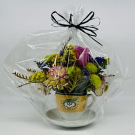 Mixed bouquet in a yellow mug with a clear wrap and black ribbon