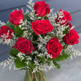 Bouquet of red roses with white filler in a glass vase
