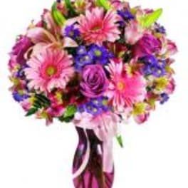 Pink and purple mixed bouquet in a glass vase with ribbon