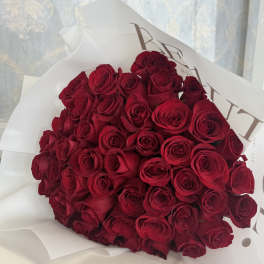 Large bouquet of red roses wrapped in white paper