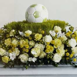 Soccer-themed floral arrangement with white and yellow flowers and a soccer ball topper