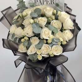 Bouquet of cream roses with eucalyptus in dark wrap