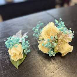 Two small floral arrangements with pale yellow roses and blue filler flowers