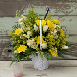 Yellow and white flower basket with a white candle