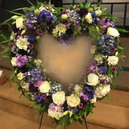 Heart-shaped floral wreath with purple, white, and blue flowers
