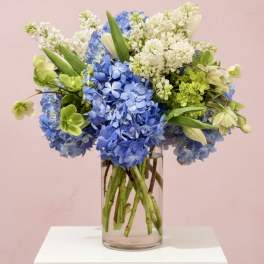 Blue and white hydrangea bouquet in a clear glass vase