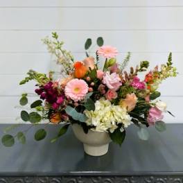 Mixed bouquet in a white vase with pink, orange, and white blooms
