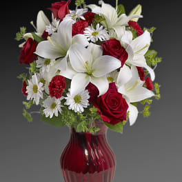 Red roses and white lilies in a red glass vase