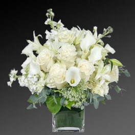 White floral arrangement in a square glass vase