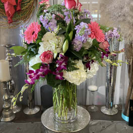 Mixed bouquet of pink, white, and purple flowers in a glass vase
