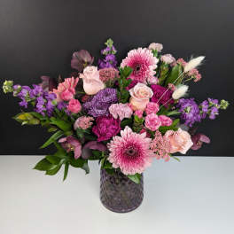 Pink and purple mixed bouquet in a textured glass vase