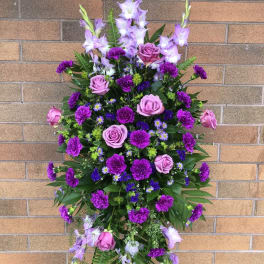 Standing floral spray with purple roses and lilies
