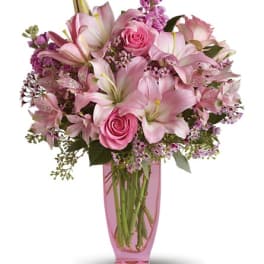 Pink lilies and roses in a pink glass vase