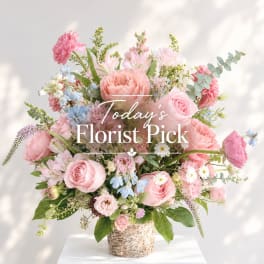 Pink and white mixed flower arrangement in a textured basket vase