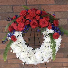 Red and white floral wreath on a black stand