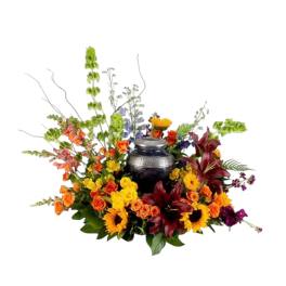 Colorful floral arrangement surrounding a dark urn