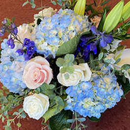 Blue hydrangeas with white and blush roses in a bouquet