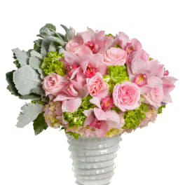 Pink roses and orchids arranged in a white vase