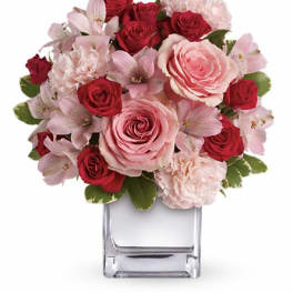 Pink and red rose bouquet in a clear square vase