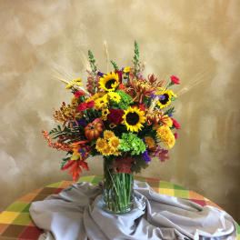 Mixed bouquet with sunflowers, roses, and chrysanthemums in a glass vase