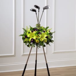 Golf clubs arranged in a floral display with yellow and purple flowers