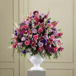 Large bouquet of pink, purple, and white flowers in a white vase