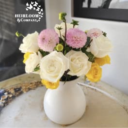 White, pink, and yellow roses in a white vase