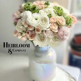 Bouquet of white, blush, and green flowers in a glass vase