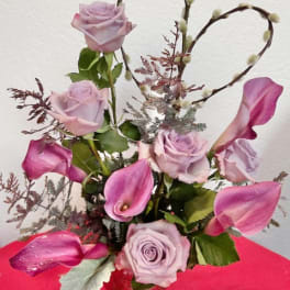 Lavender roses and pink calla lilies in a glass vase