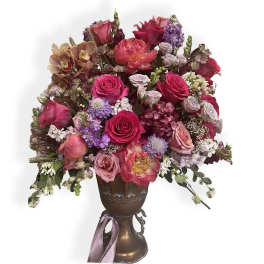 Mixed bouquet of pink and purple flowers in a bronze vase